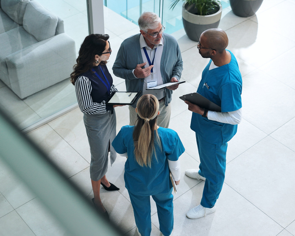 a group of people standing on the sidewalk talking on a cell phone