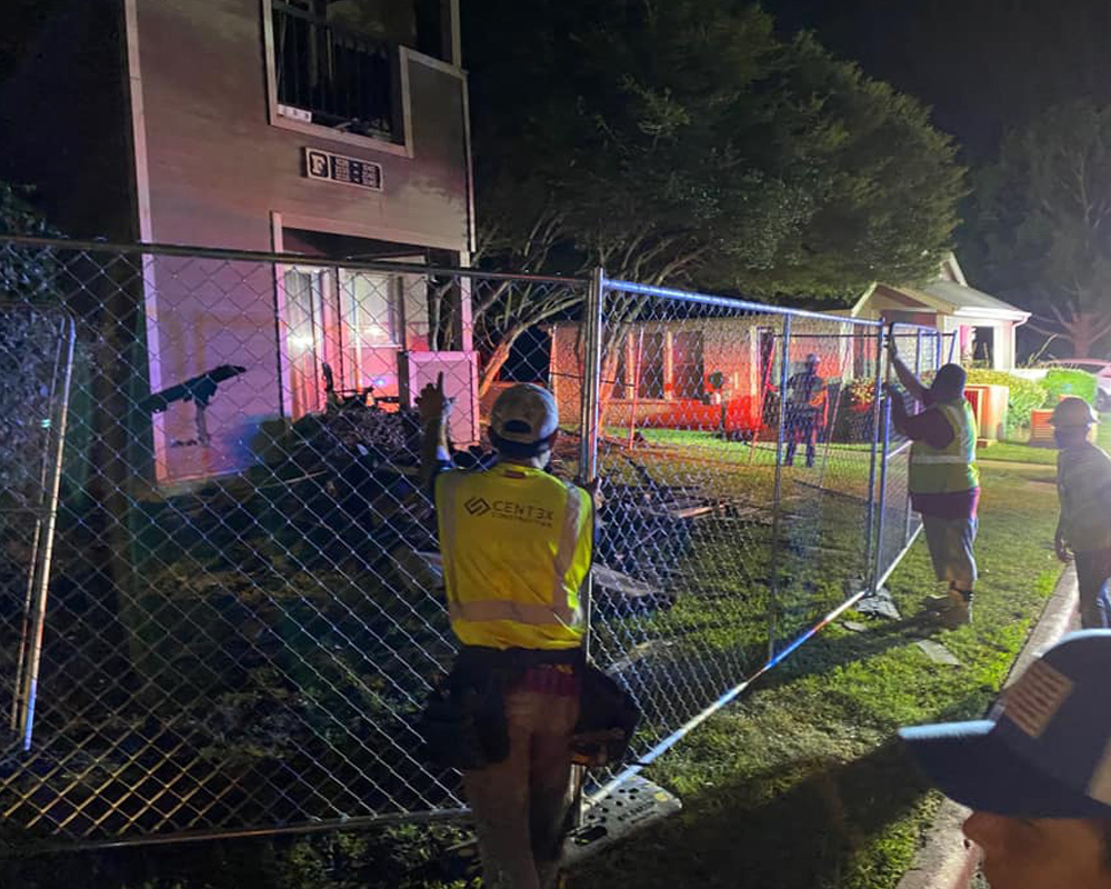 a group of people standing next to a fence