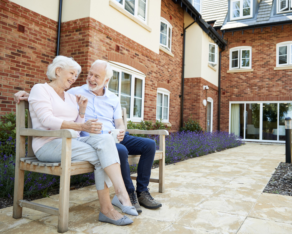 a person sitting on a bench in front of a brick building